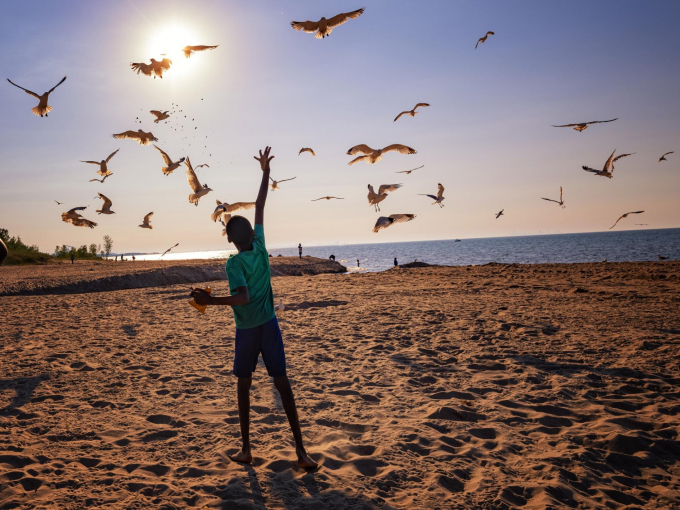 A young visitor enjoys the beach at sunset at Indiana Dunes National Park